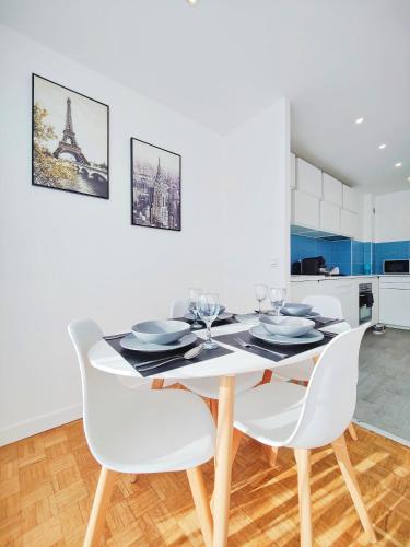 une salle à manger blanche avec une table et des chaises dans l'établissement Métro à 2 minutes Paris centre le Marais, à Romainville