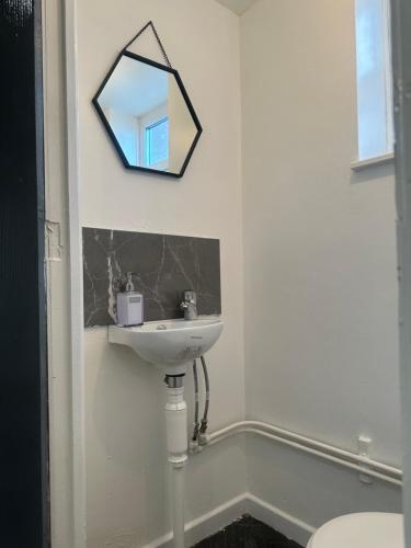 baño con lavabo y espejo en la pared en The Rodher house en Mánchester