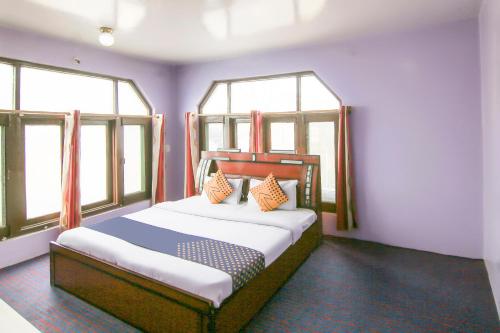 シュリーナガルにあるSPOT ON Valley Meadowのベッドルーム1室(大型ベッド1台、窓2つ付)
