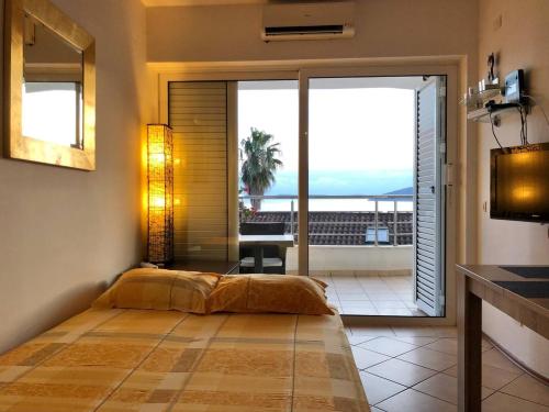 a bedroom with a bed and a balcony with a view at Boka Residence 7 in Herceg-Novi