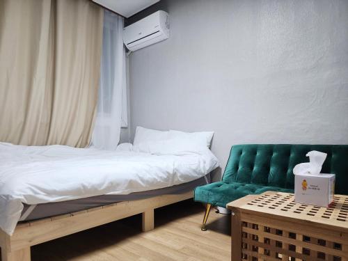 a bedroom with a bed and a green chair at Stay in North Seoul in Seoul