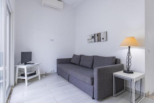 uma sala de estar com um sofá e uma televisão em Santos Nicolau In Setúbal em Setúbal