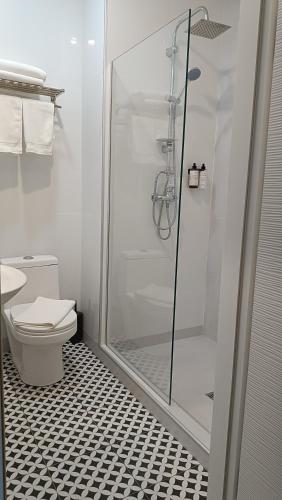 a bathroom with a toilet and a glass shower at Alliance Hotel in Tbilisi City