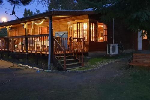 a large log cabin with a porch at night at Casa familiar yumbel con opcion a tinaja in Yumbel
