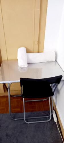 - une table avec une chaise et une serviette dans l'établissement 2 Chambre Arena - La Chapelle, à Paris