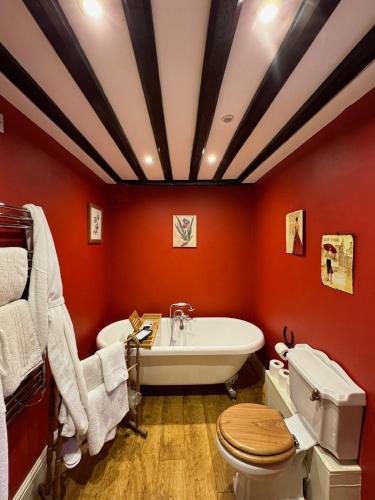 a bathroom with a white tub and a toilet at Braithwaite Hall Apartment in East Witton
