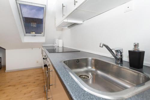 uma cozinha com um lavatório de aço inoxidável e uma janela em Come Stay in An oasis of life, comfort & style em Aarhus