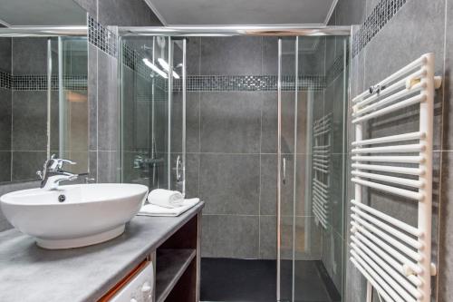 une salle de bain avec un lavabo et une douche en verre dans l'établissement Appartement rénové - Terrasse - Parking - BM, à Nice
