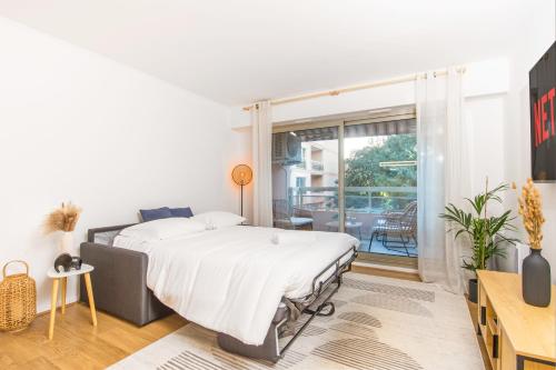 une chambre avec un lit et un balcon dans l'établissement Appartement rénové - Terrasse - Parking - BM, à Nice