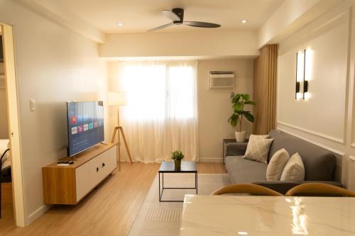 sala de estar con sofá y TV en The Cabin Tagaytay City by John Morales en Tagaytay