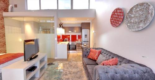 a living room with a couch and a tv at Urban Oasis Apartments at Paragon in Windhoek