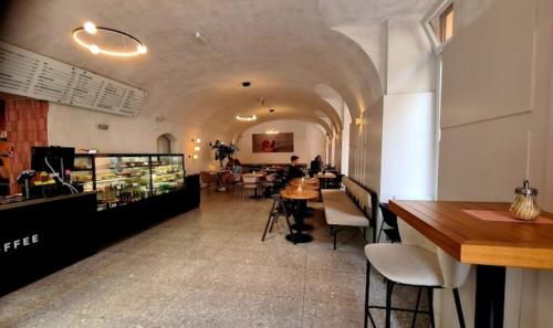 a restaurant with a long hallway with tables and chairs at Luxury Vincents Apartments Kosice in Košice