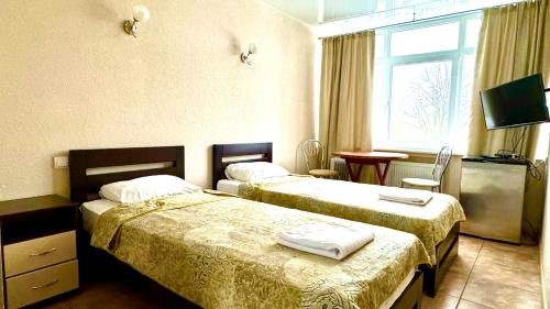 um quarto de hotel com duas camas e uma janela em База відпочинку "РіверСайд" em Novomoskovsʼk