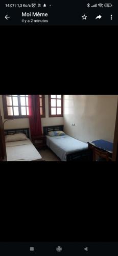 a picture of a room with two beds at Appartement meublé in Meknès