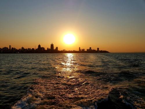 a sunset over the water with a city in the background at Room Center monoambiente estudio en pleno centro in Posadas