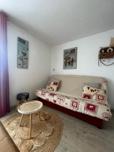 Dormitorio pequeño con cama y mesa en Chaleureux Studio Montagnard avec balcon en Prémanon