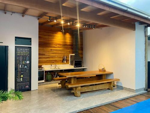 a kitchen with a wooden table and a bench at Unidades mobiliadas em condomínio in Lucas do Rio Verde