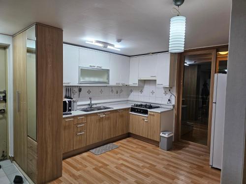 a kitchen with white appliances and wooden cabinets at Byungjeom-yeok 2 Stay 