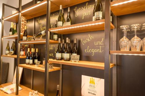 - une salle de dégustation de vin avec des bouteilles de vin sur les étagères dans l'établissement Gästehaus Julianenhof, à Nierstein