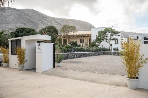 a building with a courtyard with potted plants at SN Santorini Apartments in Kamari
