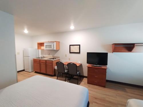um quarto com uma cama e uma cozinha com um micro-ondas em WoodSpring Suites Asheville em Asheville