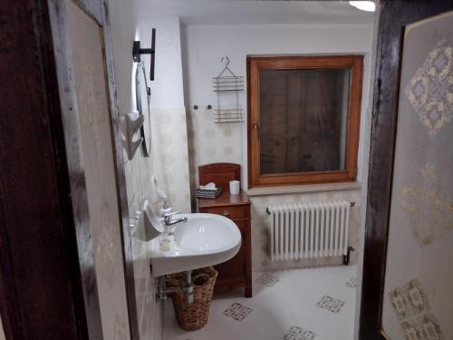 a small bathroom with a sink and a window at Casa Sirena in Canale dʼAgordo