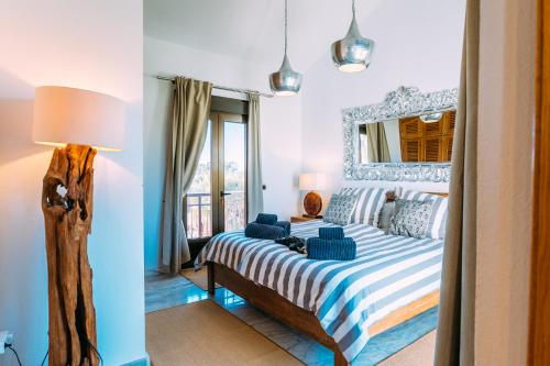 a bedroom with a bed and a mirror on the wall at Paradise Beach House: piscina privada, playa 100m in Corralejo