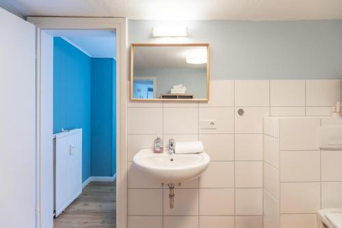 ein Bad mit einem Waschbecken und einem Spiegel in der Unterkunft Mok fast in Husum