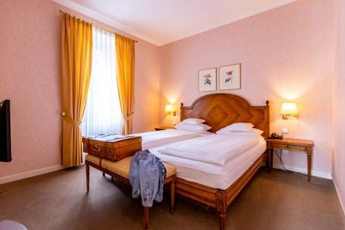 a bedroom with a large bed and a large window at Romantik Hotel Zehntkeller in Iphofen