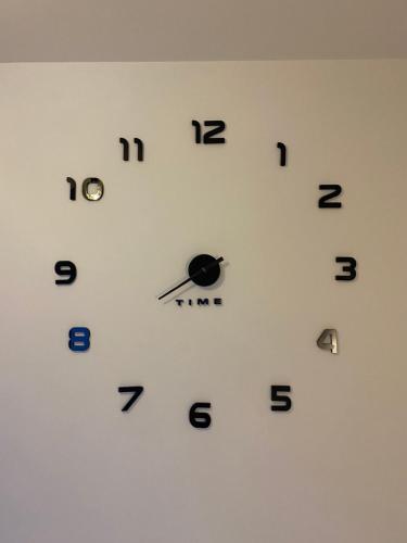 a white clock with black numbers on a wall at Castello apartman Kopaonik in Kopaonik