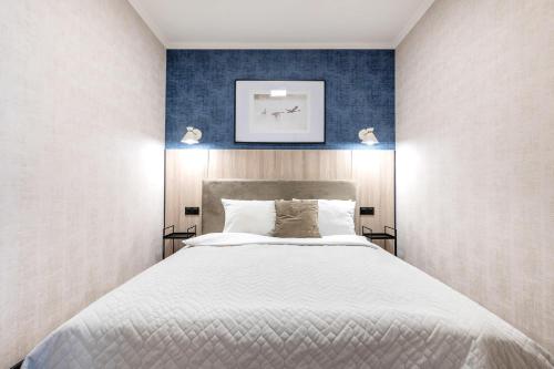 ein Schlafzimmer mit einem großen Bett mit blauer Wand in der Unterkunft LIKE LAKES UKIEL PARK 40 parking FV in Olsztyn