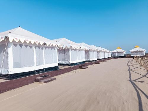 a row of white tents on the beach at Rann Heritage Resort in Dhordo