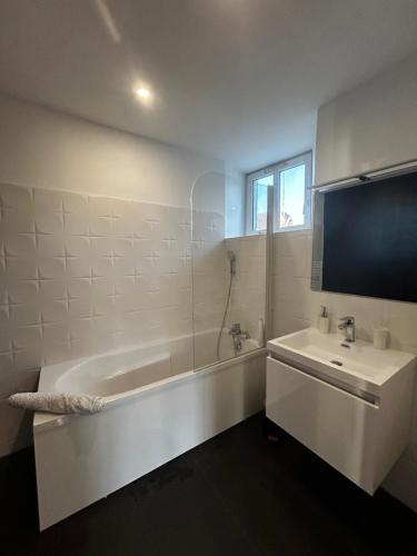 un bagno bianco con vasca e lavandino di L'indus chic a Bourges