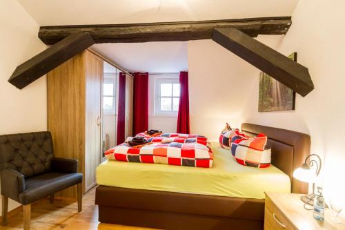 a bedroom with a bed and a chair at Gutshof-Loft Sonnenschein in Klein Upahl