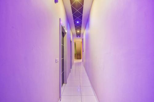 Kurukshetra的住宿－OYO Hotel Sarovar，走廊设有紫色墙壁和瓷砖地板
