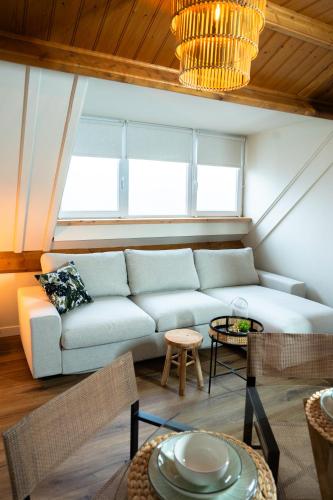 a living room with a couch and a table at Herberg de Boelekeerl in Halle