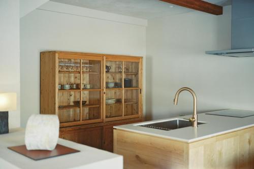 uma cozinha com um lavatório e um armário de madeira em Portside Inn Hakodate em Hakodate