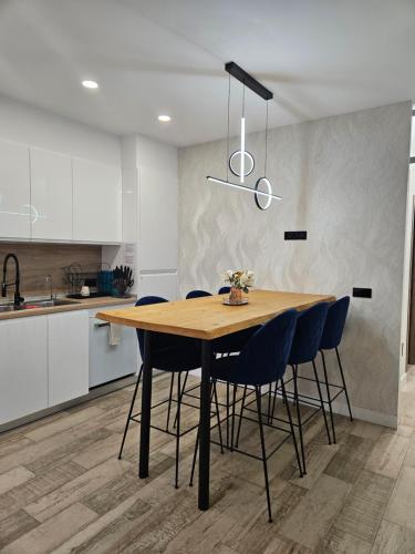 a kitchen with a wooden table and blue chairs at Habitación céntrica de Lujo Gv 6 in Valencia