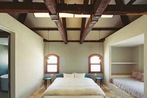 a bedroom with a large bed and two windows at Portside Inn Hakodate in Hakodate