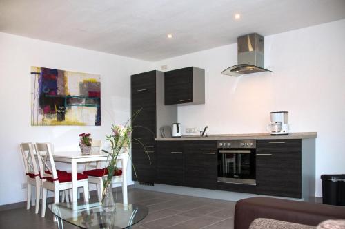 une cuisine avec une table, un évier et une cuisinière dans l'établissement Ferienwohnungen Moselterrasse, à Detzem