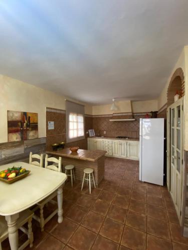 a kitchen with a table and a white refrigerator at Casas Guemon in Zahora