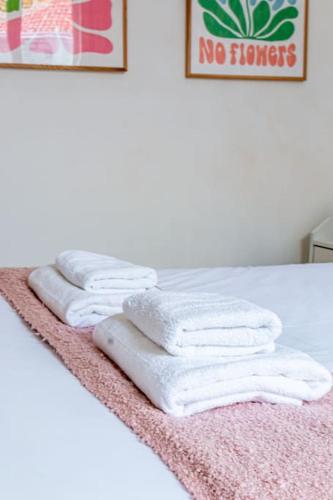 4 serviettes blanches sont empilées sur un lit dans l'établissement Flat next to Montparnasse train station - II, à Paris