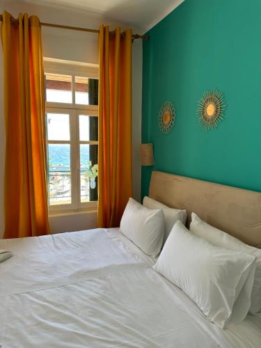 a bedroom with a white bed with a window at Akteon Rooms in Agia Galini