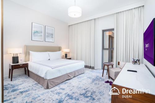 a hotel room with a bed and a desk at Dream Inn - Address Beach Residence - Luxury Apartments in Fujairah