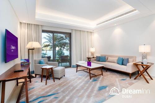 Dream Inn - Address Beach Residence - Luxury Apartments في الفجيرة: غرفة معيشة مع أريكة وطاولة