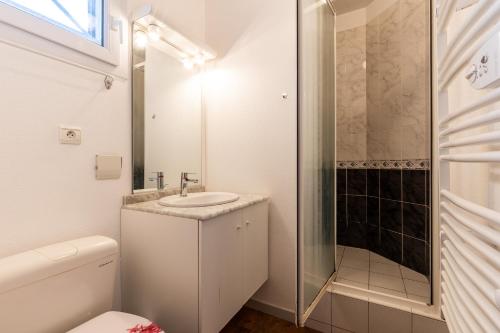 een witte badkamer met een wastafel en een douche bij Cap-ferret Phare Réf 130 in Lège-Cap-Ferret