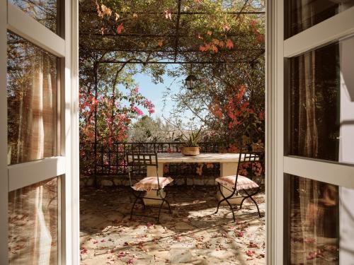 a view of a table and chairs from a window at Almeira 4acre Estate, for Unparalleled Seclusion, By ThinkVilla in Zakynthos