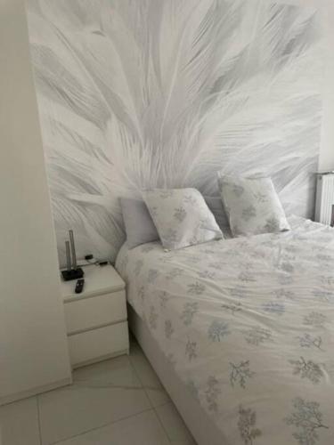 - une chambre dotée d'un lit avec un mur en plumes dans l'établissement T4 Chaleureux et moderne, à Saint-Leu-la-Forêt