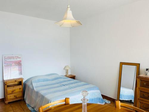 une chambre avec un lit, une commode et un miroir dans l'établissement Appartement Résidence Santa Giulia Calvi, à Calvi