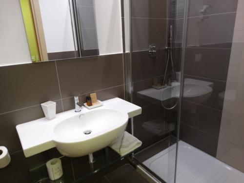 a bathroom with a sink and a glass shower at Hotel Il Cantico St. Peter in Rome